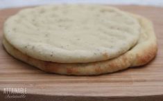 two pita breads sitting on top of a cutting board next to each other