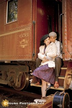 a man and woman are hugging on the train tracks