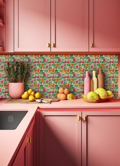 a kitchen with pink cupboards and colorful wallpaper