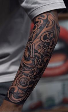 a man's arm with a clock and letters tattoo design on the left arm