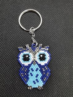 an owl keychain is shown on a black surface with the image of an owl