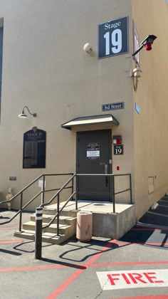 an entrance to a building with stairs leading up to the door and numbers on the wall