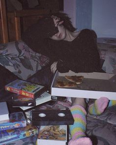 a woman sitting on a couch with pizza in her lap and other books around her