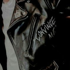 a person wearing a black leather jacket with the word swwnme written on it