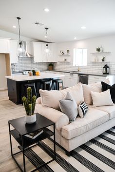 a living room filled with furniture next to a kitchen