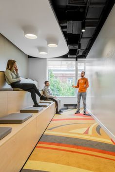 people are sitting and standing in an office waiting for their turn to the meeting room