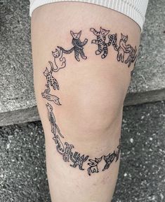 a woman's leg with tattoos on it that have cats in the shape of a heart