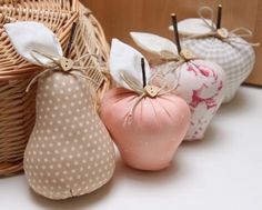 three decorative pears sitting next to each other in front of a wicker basket