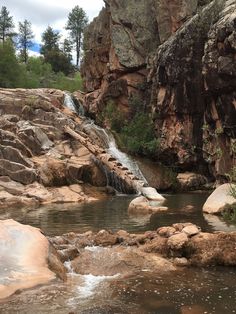 there is a small waterfall coming out of the rocks