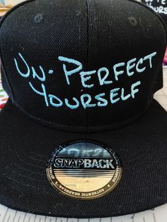 All black 100% polyester snapback hat with the words "UN-PERFECT YOURSELF" stitched across the front in customer choice of color. Please see second picture of listing to choose your color, type the code or color name in the personalization box. Having been a perfectionist most of my life, I needed a reminder that it is not the right path to take. Even if I falter, I can remember to just keep un-perfecting myself. It's okay to make mistakes - be kind to yourself. Make Mistakes, It's Okay, Be Kind To Yourself, Custom Hats, Making Mistakes, Life I, Snapback Hat, Color Names, Be Kind