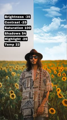 a man standing in front of a field of sunflowers wearing a hat and sunglasses