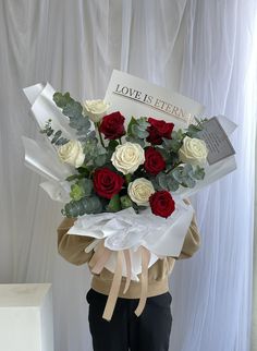 a woman holding a bouquet of roses in her hands