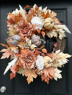 a wreath with flowers and leaves on the front door