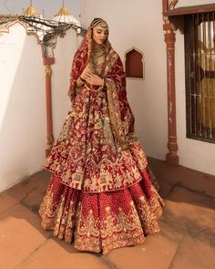 a woman in a red and gold bridal gown