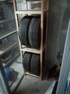 several tires are stacked on top of each other in a storage area with wire mesh walls