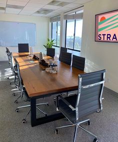 an empty conference room with chairs and a wooden table