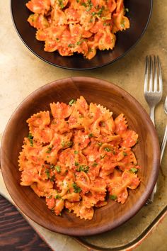 two plates of pasta with tomato sauce and parsley