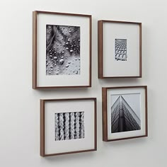 three framed photographs hang on the wall next to each other, one with raindrops