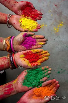 several hands with different colored powder on them