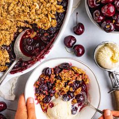 a bowl of ice cream with cherries and crumbles