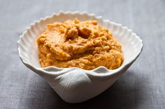 a white bowl filled with food sitting on top of a table next to a napkin