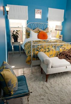 a bed room with a neatly made bed and blue walls