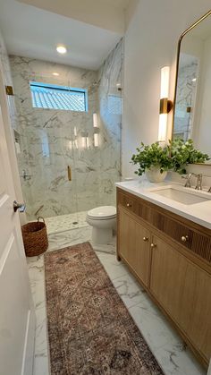 a bathroom with a rug, sink and toilet in it's center piece is shown