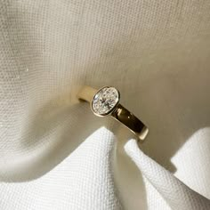 a diamond ring sitting on top of a white cloth