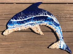 a blue and white dolphin sculpture sitting on top of a wooden deck