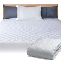 an image of a bed with white sheets and blue pillows on top of it, next to a pillow