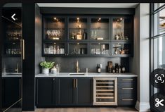 a kitchen with black cabinets and gold trim on the countertop, along with a wine glass cabinet