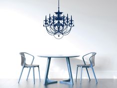 a chandelier hanging from the ceiling over a dining room table with two chairs