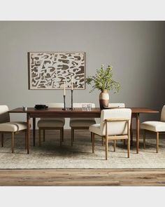 a dining room table with chairs and a vase filled with flowers on top of it