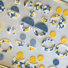 a close up of many different shapes and sizes on a sheet of white paper with yellow and blue circles