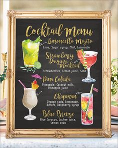 a chalkboard sign with cocktails on it in front of a table and flowers