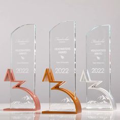 three awards are shown in different colors and sizes, including one with an arrow on it