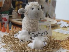 a stuffed sheep holding a sign that says quarani in front of other toys