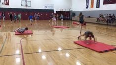 a group of people doing exercises on mats in a gym