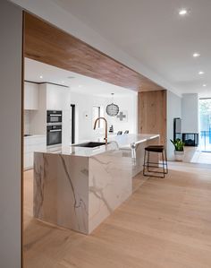 a modern kitchen with marble counter tops and wooden flooring