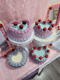 three cakes with cherries on them are sitting on a table in front of a mirror