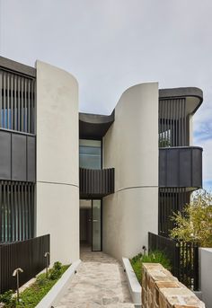 the building has two balconies on each side and is made of concrete with black slats