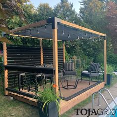 a wooden gazebo sitting on top of a lush green field