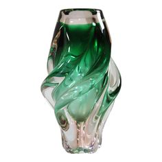 a green and white glass vase sitting on top of a table