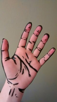 a person's hand with black lines painted on it