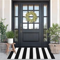 a black and white striped rug with a wreath on the front door