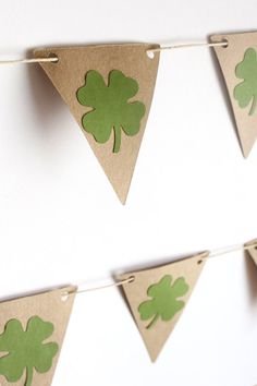 some paper shamrocks are hanging on a string