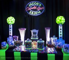 the candy bar is set up with neon lights and candies on it's table