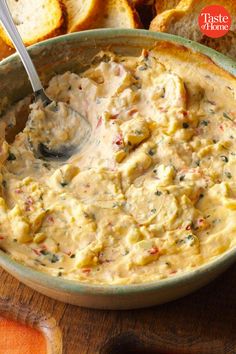 a bowl of dip with bread in the background