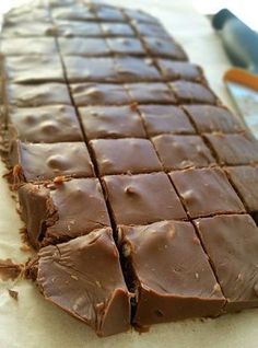 a close up of a piece of chocolate cake on a table with a spatula in the background