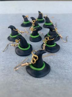 black and green witch hats with gold chain earrings on grey concrete surface, closeup